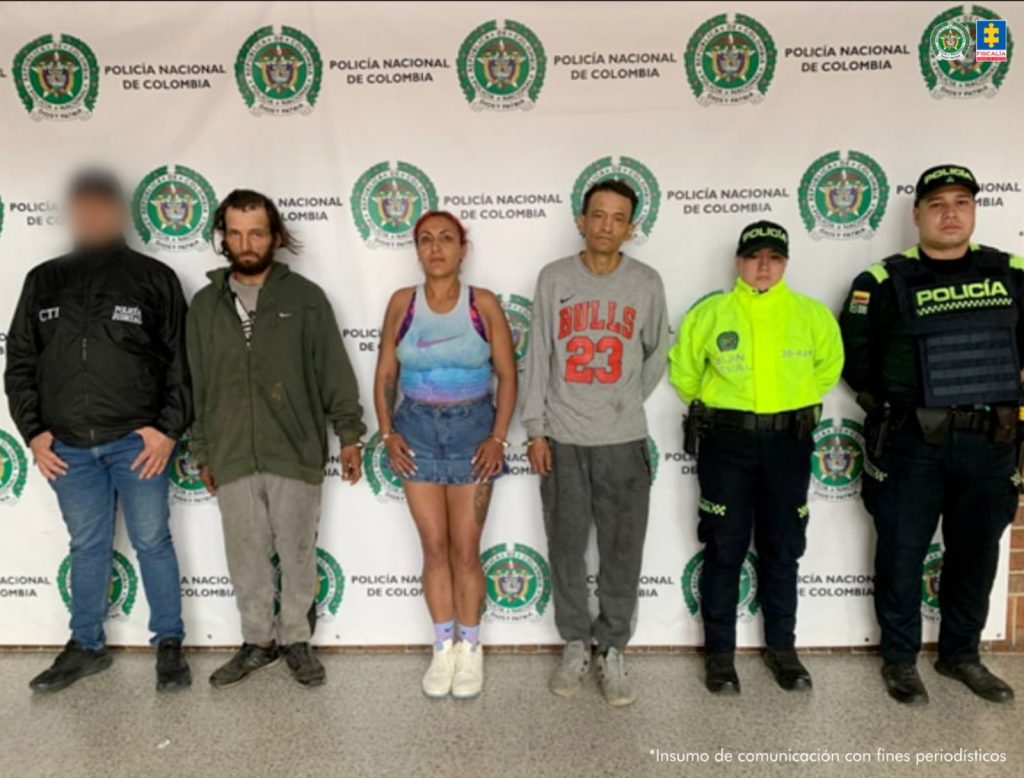 En la fotografía se aprecian de pie, en hilera y esposados entre sí, a tres de los cuatro presuntos integrantes de ‘Los Gnomos’. Entre ellos hay una mujer. Al extremo derecho de ellos hay un servidor del CTI de la Fiscalía y al extremo izquierdo un uniformado de la Policía Nacional. Detrás de ellos hay un pendón institucional de la Policía.