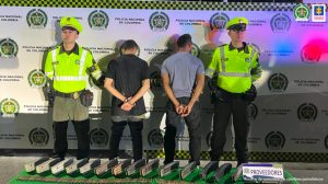 En la fotografía se aprecia de espaldas a la cámara a Milton Julio Arroyo Tamayo y Wilmar Andrés Arroyo Suárez. A lado y lado de ellos hay uniformados de la Policía Nacional. En el piso y sobre una tela verde hay unos elementos. En la parte posterior hay un pendón de la Policía.