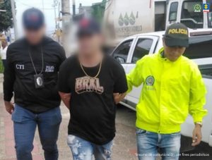 En la imagen aparece una persona caminando entre dos uniformados de la Policía y el CTI.