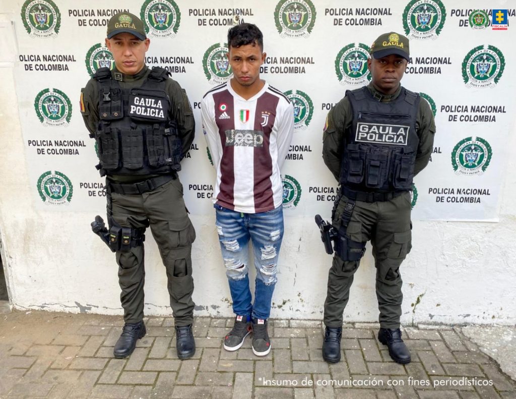 En la imagen aparece un joven, con camiseta deportiva y jean, detenido entre dos uniformados de la Policía Nacional.