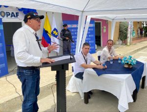 En la imagen se ven dos funcionarios de la Fiscalía, junto con un ciudadano frente a la entrada de un PAF, custodiada por un servidor del CTI.