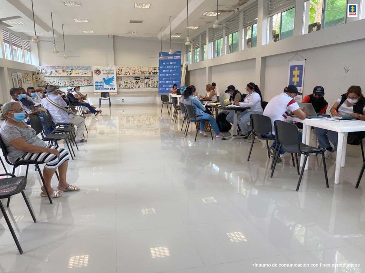 Panorámica del escenario donde se atienden las víctimas. Se observa un grupo de ciudadanos y varios funcionarios en las mesas de trabajo.