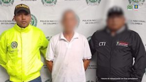 En la imagen aparece un señor de camisa blanca entre un uniformado de la Policía y uno del CTI.