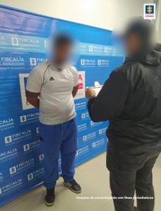 En la fotografía aparece un hombre delante de un pendón de la Fiscalía con un uniformado del CTI que le lee sus derechos.