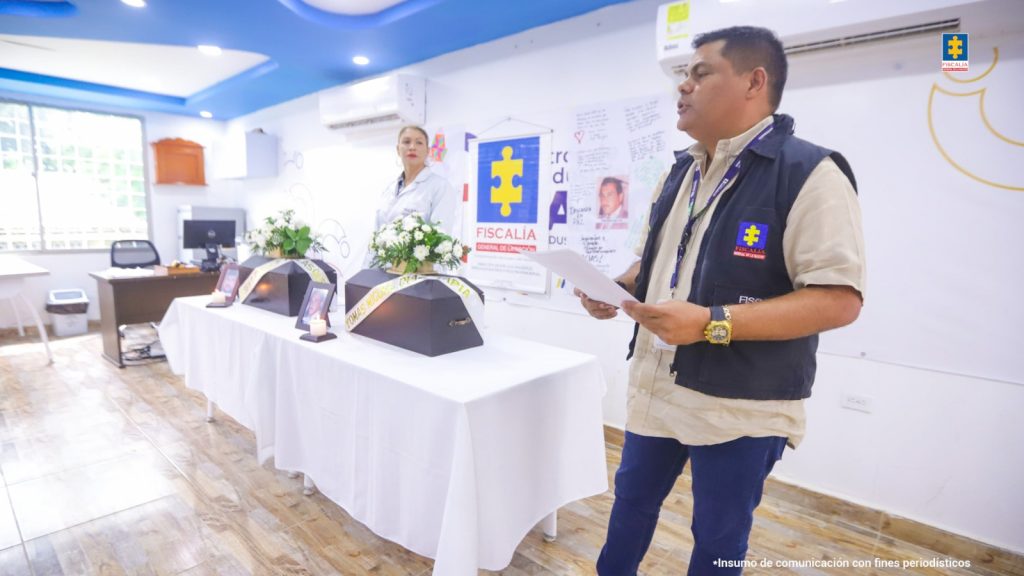 En la fotografía aparecen funcionarios de la Fiscalía y familiares de víctimas al interior de un salón recibiendo los restos de sus seres queridos.