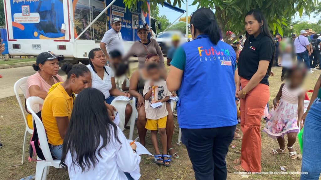 fotografia en donde se puede ver a una funcionaria de la fiscalia con un chaleco azul que dice "futuro colombia" hablando con algunos habitantes de la jornada