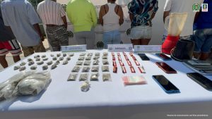  En la fotografía se identifican encima de una mesa con mantel blanco, varias bolsitas plásticas con sustancias estupefacientes y celulares.