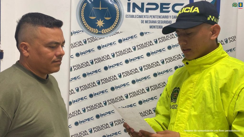 En las imágenes aparecen dos personas, una de suéter verde y la otra de suéter amarillo, frente a un uniformado de la Policía quien les está leyendo una notificación judicial.