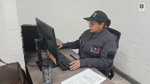 En la fotografía aparece una servidora del CTI de la Fiscalía, con su uniforme de color gris, gorra, sentada en un escritorio, realizando labores propias de su cargo en un computador ubicado en el PF de Los Mangos.