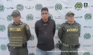 En la fotografía se observa a un hombre con buzo negro y jean custodiado por dos uniformados de la Policía Nacional.