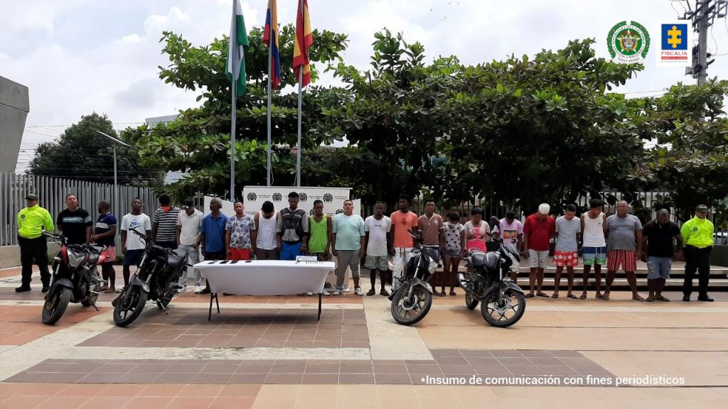 En la imagen se observa a los capturados custodiados por uniformados de la Policía Nacional. En una mesa blanca se notan algunos elementos que les fueron incautados.