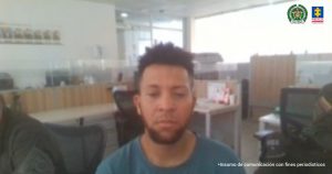 En la imagen se observa a un hombre sentado, moreno con pelo crespo y barba, vestido con una camiseta gris.