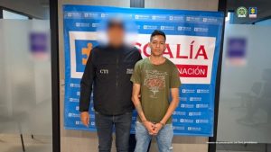 Se visualiza al sentenciado junto a un investigador del CTI. Detrás de ellos el banner que identifica a la Fiscalía General de la Nación.