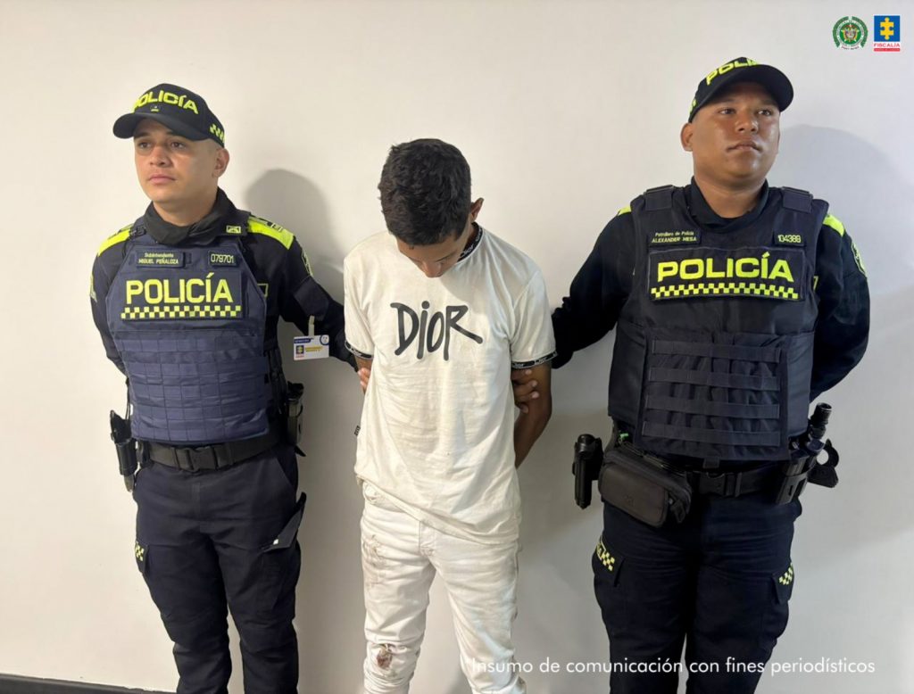 Se visualiza al capturado con dos uniformados de la Policía Nacional.