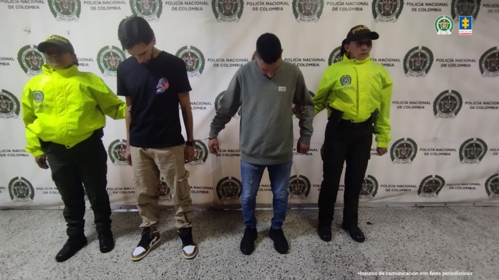 En la fotografía están los dos capturados mirando al piso y dos servidores de la Policía Nacional a los lados.