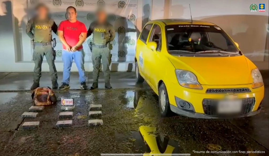 Se visualiza al capturado junto a dos uniformados de la Policía Nacional. Frente a ellos la sustancia incautada. Detrás de ellos el banner que identifica a la Policía Nacional.