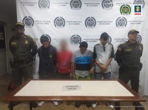 En la fotografía se observa a los tres asegurados junto a dos agentes de la Policía Metropolitana, Mecal. En la parte superior se observa un banner de la Policía Nacional. 