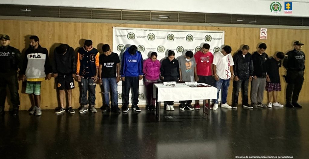 En la imagen están los 13 procesados con dos servidores del Gaula de la Policía Nacional.