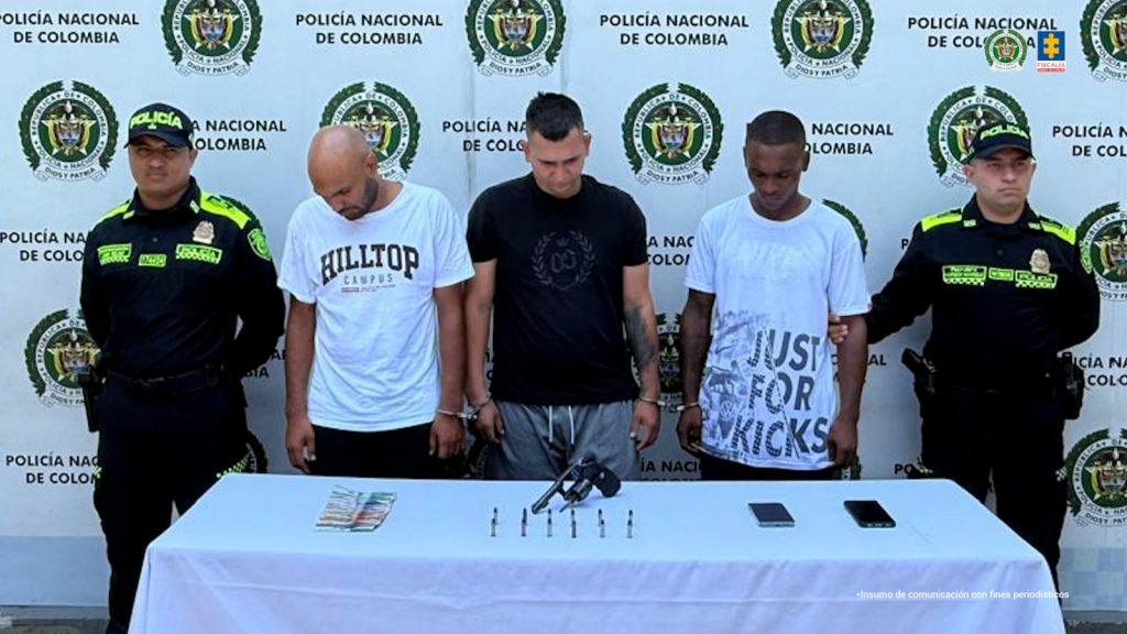 En la fotografía aparecen de pie y esposados entre sí Gabriel Ángel Valencia Solís, Andrés Felipe González Molina y Yeison Steven Correa Garzón. De izquierda a derecha, uno tiene la cabeza rapada y usa barba; viste con camiseta de mangas cortas, de color blanco, con estampado en el pecho y pantalón negro. Otro viste con camiseta negra de mangas cortas y estampado gris oscuro a la altura del pecho, así como pantalón gris. El otro viste con camiseta de mangas cortas, de color blanco, con estampado de letras de color gris en la parte inferior de la camiseta, así como pantalón oscuro. A los extremos de ellos hay uniformados de la Policía Nacional. Delante de ellos hay una mesa con mantel blanco y sobre ella se ve un arma de fuego, munición, dos teléfonos celulares y dinero en efectivo. Detrás de ellos hay un pendón institucional de la Policía.
