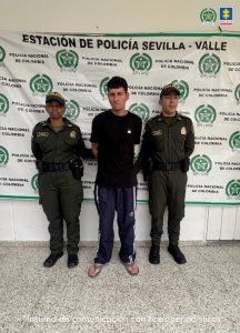 En la fotografía aparece de pie y con los brazos atrás Geiler Andrés Tangarife Botero. Viste con camiseta de color negro y pantalón de sudadera negro con franjas blancas a los lados. Usa pantuflas. A los Extremos hay uniformados de la Policía Nacional. Detrás de ellos hay un pendón institucional de la Policía.