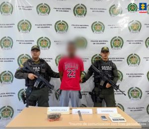 En la fotografía aparecen lo tres capturados junto a un infante de la Armada y cinco agentes de la Policía Nacional. En la parte superior esta un banner de la Policía Nacional y otro banner de la Armada Nacional