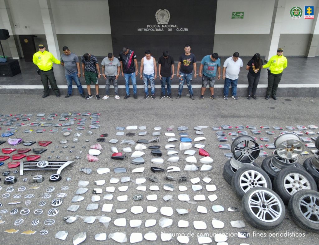 Se visualiza a los capturados junto a uniformados de la Policía Nacional. Frente a ellos las 1000 autopartes incautadas. Detrás de ellos el banner que identifica a la Policía Nacional.
