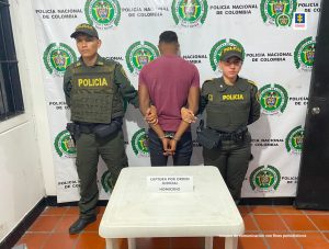 en la foto aparecen dos miembros de la Policía custodiando al hoy asegurado, quien se encuentra de espaldas.