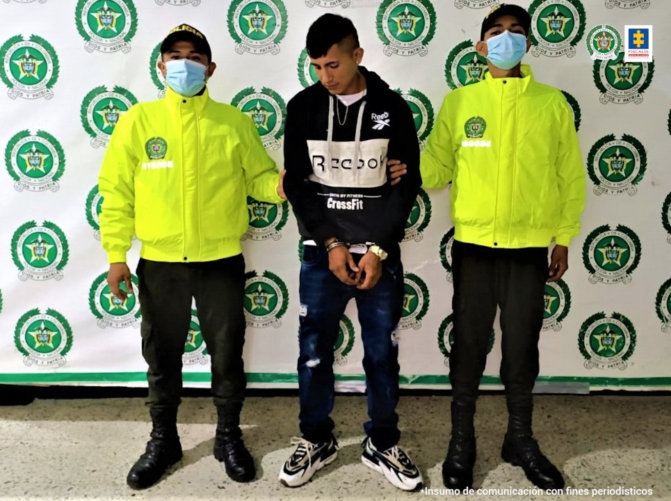 El capturado se encuentra con sus manos esposadas y está custodiado por dos uniformados de la SIJIN Casanare y de fondo hay un pendón de la institución.