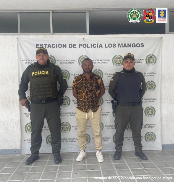 En la fotografía aparece un hombre capturado junto a dos agentes de la Policía de Cali. En la parte posterior se ve un banner de la Policía Metropolitana Cali
