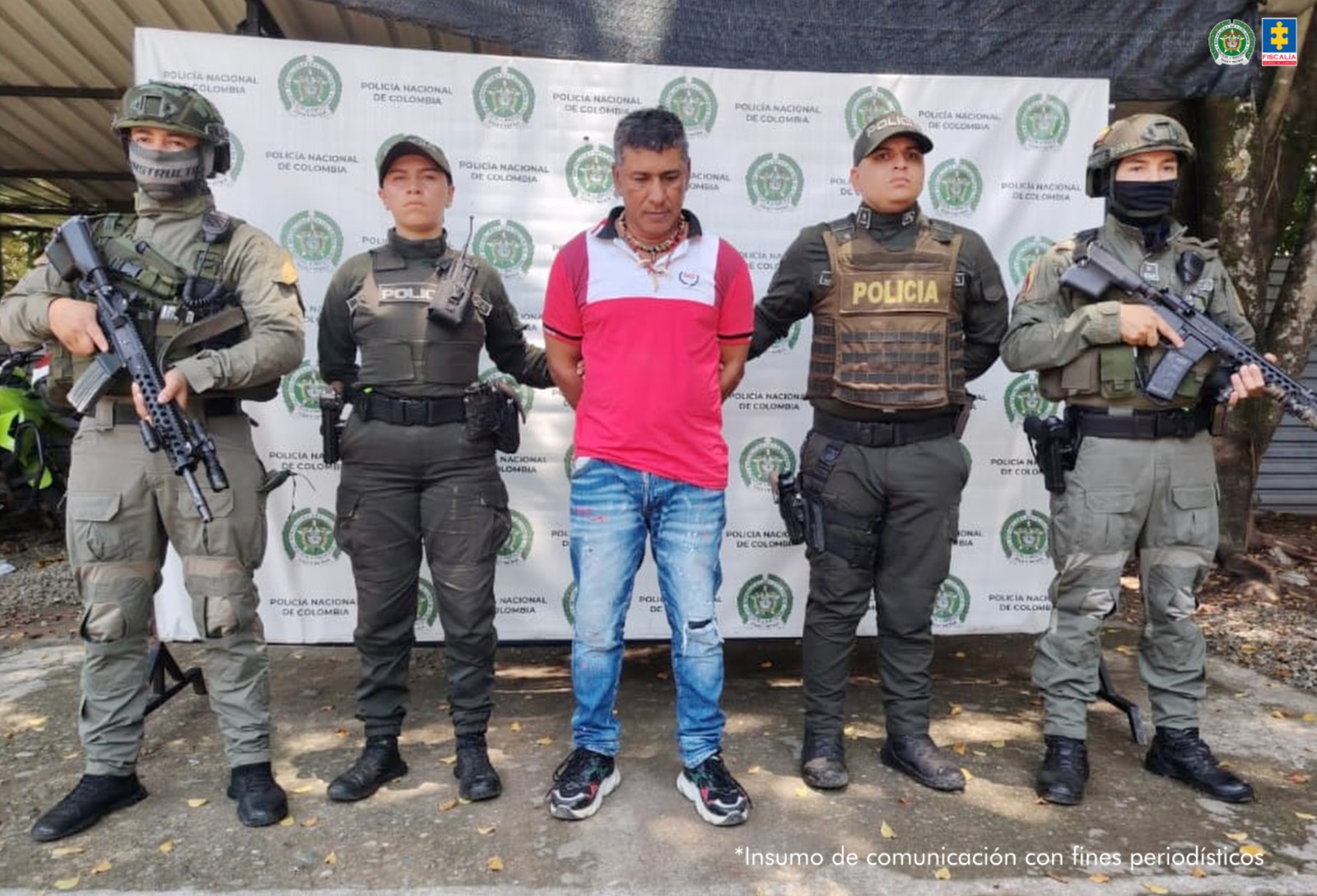En la fotografía aparece de pie y con los brazos atrás, Harol Cárdenas Salamanca. Viste con camisa de mangas cortas y cuello, de color rojo, con franja blanca en el pecho; jean azul desgastado y zapatillas negras con zuela blanca. A sus extremos hay uniformados de la Policía Nacional. Detrás de ellos hay un pendón institucional de la Policía.