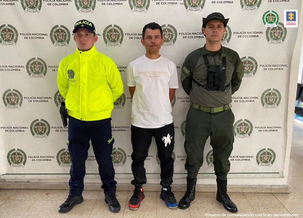 En la fotografía está el procesado con dos servidores de la Policía Nacional
