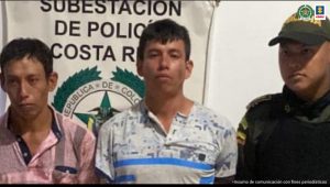 En la fotografía se aprecia a los hermanos Víctor Andrés y Dayron Fernando Ramírez Tumiñá, de pie y con los brazos atrás. Uno de ellos viste camisa de manga corta rosada con franjas grises y jean azul. El otro viste camisa de manga corta blanca, con franjas azules y estampados grises a la altura del pecho, así como pantalón amarillo. A lado y lado de ellos hay uniformados de la Policía Nacional. Delante de ellos hay una mesa y sobre ella un letrero que dice ‘Capturados por el delito de homicidio’. Detrás de ellos hay un pendón institucional de la Subestación de Policía de Costa Rica.
