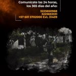 La imagen es una pieza gráfica institucional informativa de la Fiscalía General de la Nación, relacionada con los canales de comunicación disponibles para el reporte de situaciones de riesgo. En la parte superior se muestra un fondo oscuro con tonos negros y naranjas, que simulan humo o fuego como recurso gráfico. Sobre este fondo se encuentra el siguiente texto en color blanco y amarillo: “Comunícate las 24 horas, los 365 días del año:” 3223650968 3223653331 +57 601 5702000 Ext. 31409 El texto destaca los números de contacto disponibles de manera permanente para la atención ciudadana. En la parte inferior de la imagen se observa una fotografía en un entorno exterior con vegetación y senderos. En el centro aparece una persona utilizando un traje protector especializado, que avanza por el lugar. La imagen cuenta con un efecto gráfico de textura oscura alrededor, en coherencia con la identidad visual de las piezas anteriores. La composición combina fotografía y diseño gráfico institucional, sin identificar personas ni situaciones específicas.