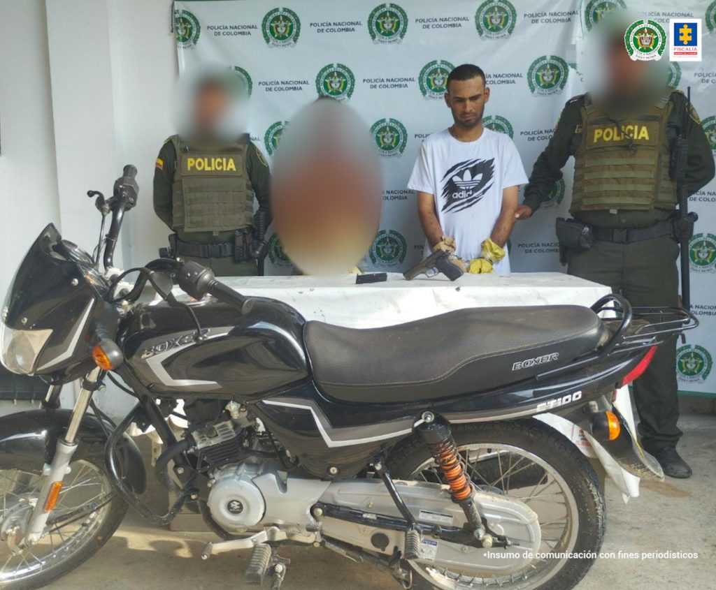 En la imagen se ven dos personas capturadas, con las manos cubiertas, entre dos policías.