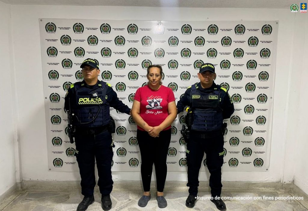 En la foto aparece la mujer capturada custodiada por uniformados de la Policía Nacional. En la foto también aparece de fondo un backing de la Policía Nacional.