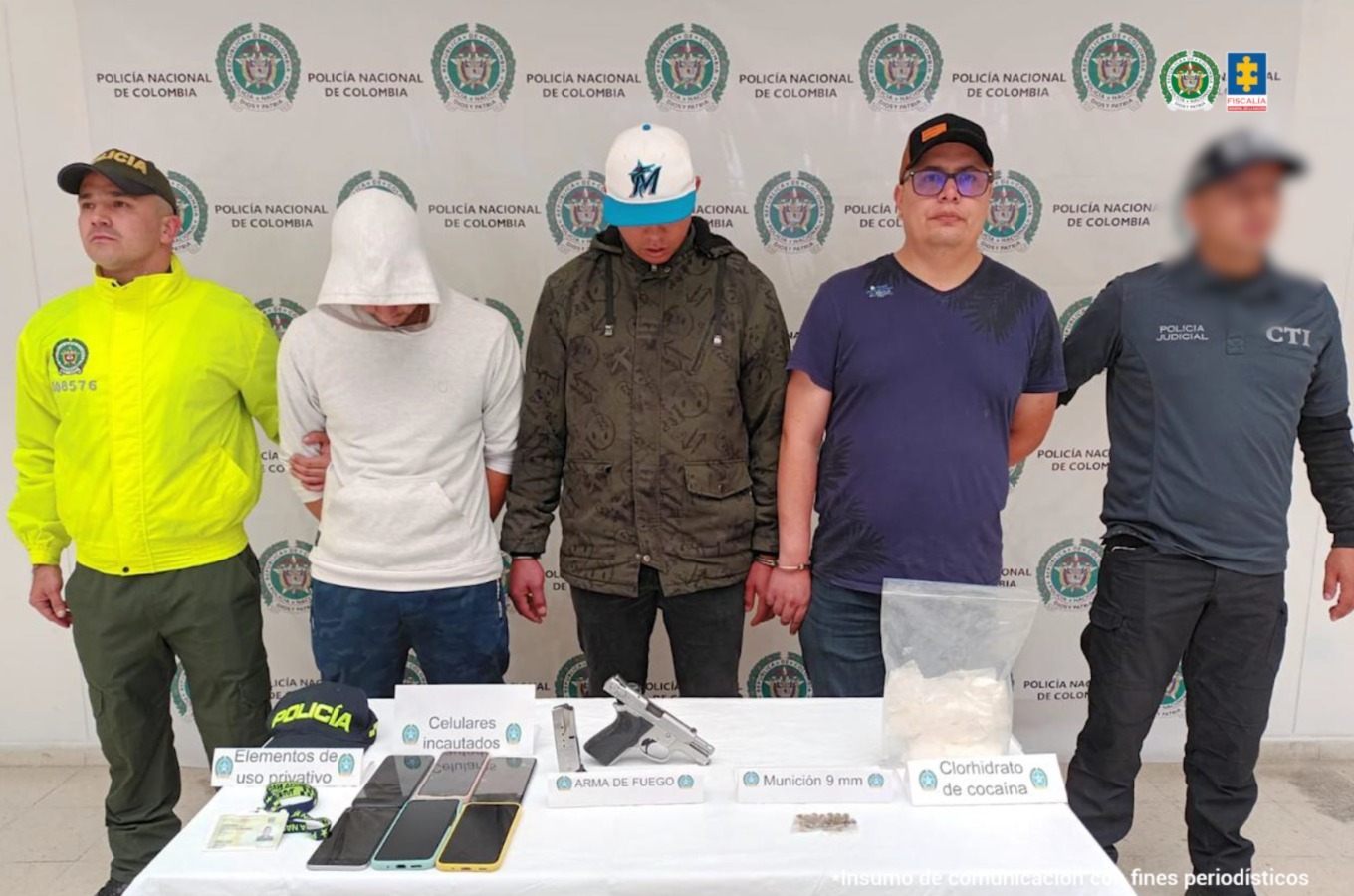 En la imagen aparecen los tres hombres capturados, aunque no puede distinguirse el rostro de los tres debido a que usan gorras y sacos. Junto a ellos hay miembros del CTI y de la Policía. Al fondo hay un banner de esta última institución.