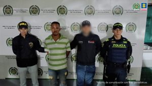En la foto aparece el capturado custodiado por un servidor del Cuerpo Técnico de Investigación y dos uniformados de la Policía Nacional. De fondo aparece un backing de la Policía Nacional.