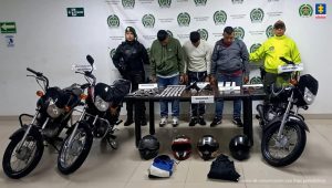 En la fotografía se aprecia a de pie y con los brazos atrás a Hugo Herney Ramírez Murillo; Cristian Leandro Alzate Soto; así como a José Didier Ramírez Murillo al imputado. A sus extremos hay uniformados de la Policía Nacional. Delante de ellos hay una mesa color marrón y sobre ella varios elementos como un arma de fuego, munición, bolsas plásticas con contenido blanco; asimismo, tres motocicletas y en el piso se aprecian cuatro cascos para motociclistas y dos morrales. Detrás de ellos hay un pendón institucional de la Policía.