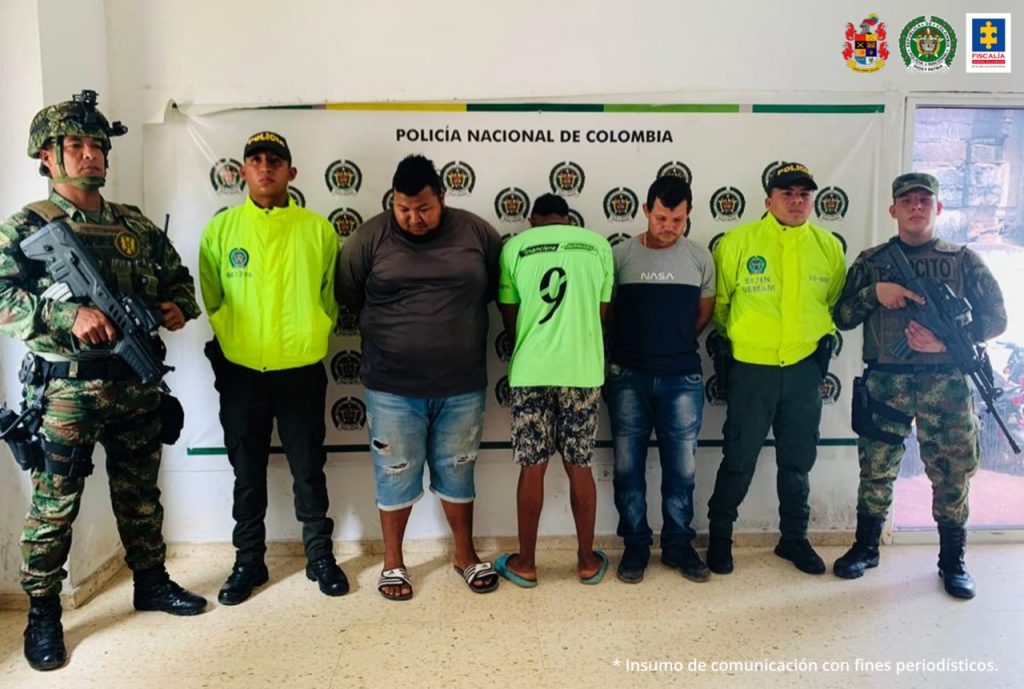 Se puede apreciar en la foto dos funcionarios de la Policía y el Ejército custodiando a los tres capturados.