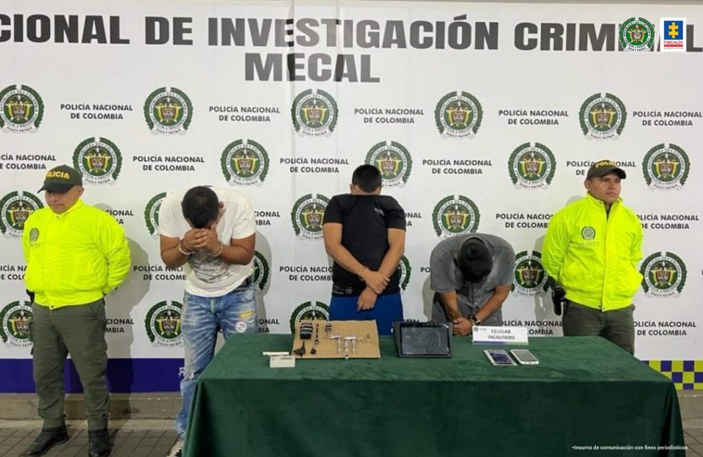 En la fotografía se observa a los tres capturados junto a dos agentes de la Policía Metropolitana, Mecal. En la parte posterior se observa una mesa con llaves metálicas, inhibidores de señales de alarma, dos teléfonos celulares, y en el suelo dos llantas y autopartes de vehículos. 