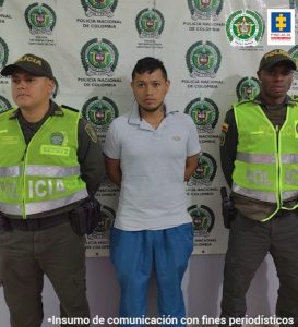 En la fotografía aparece el capturado juntos a dos agentes de la Policía. En la parte superior se observa un banner de la Policía Nacional.