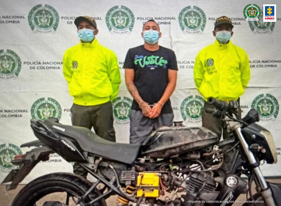 en la foto se aprecia a dos Policías custodiando al capturado y la moto en la que se movilizaba el día de los hechos.