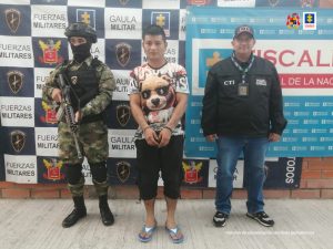 en la imagen se ve un hombre detenido bajo custodia del CTI y un integrante del Ejército componente Gaula. Detrás suyo backings institucionales.