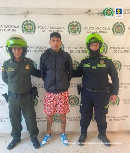 El hombre presuntamente implicado en un homicidio es custodiado por dos uniformados de la Policía Nacional.