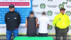 Fiscal Martha Mancera, Martha Mancera, Fiscal Mancera Se observa al capturado de frente con un efecto que difumina su rostro. A cada costado un uniformado de Policía Nacional. Atrás un pendón de Policía Nacional