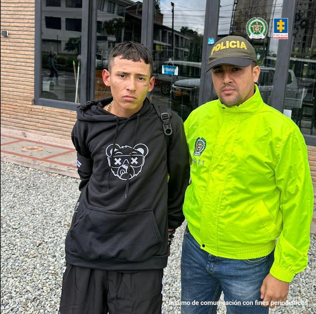 El capturado aparece con las manos en la espalda, junto a un miembro de la Policía.