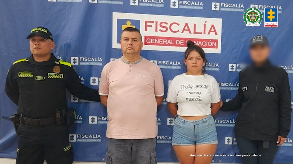 En la foto aparecen Pedro Julio Triana en Bogotá y a Nicol Geraldine Duarte acompañados a los lados por funcionarios del CTI y la Policía Nacional. Al fondo el pendón con logos de la Fiscalía.