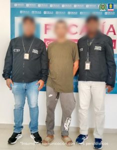 En la imagen aparece una persona de suéter café, entre dos uniformados del CTI.