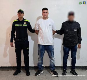 En la foto aparece el capturado de frente y custodiado por un servidor del Cuerpo Técnico de Investigación (CTI) y un uniformado de la Policía Nacional. 
