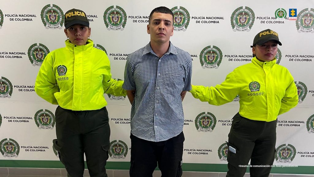 En las imágenes aparecen los capturados esposados y custodiados por uniformados de la Policía Nacional, de fondo aparecen pendones institucionales de la fuerza pública.